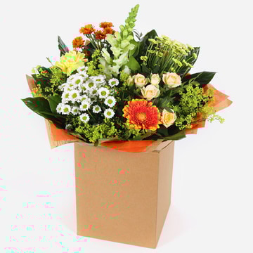 Citrus sunrise bouquet with yellow white and orange flowers in kraft gift box