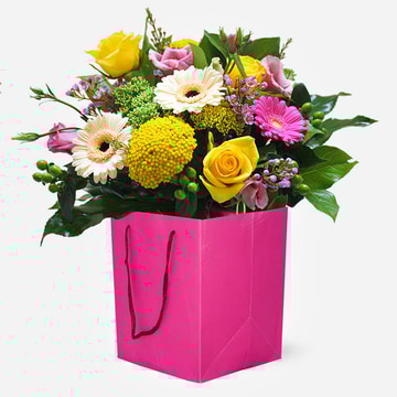 Sugar pop vibrant hand tied bouquet with cerise pink and yellow flowers in a bright pink gift bag