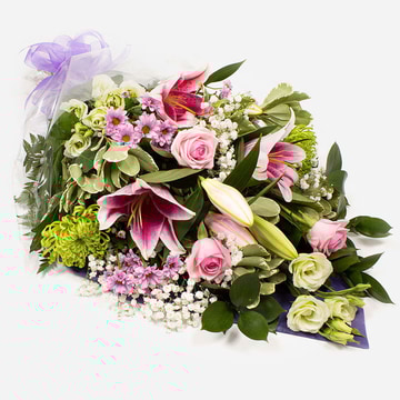 Pink green and white funeral bouquet with roses and lilies wrapped in cellophane