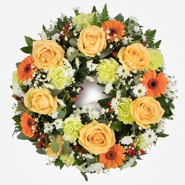 Peach and green funeral wreath with roses germini and seasonal foliage