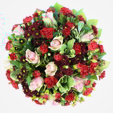 Red and pink funeral posy with roses carnations and mixed greenery on a 10 inch pad