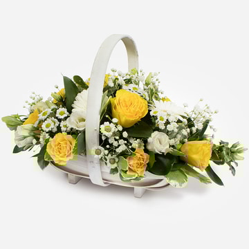 Yellow and white funeral flower basket with roses gerbera and mixed foliage in a white trug