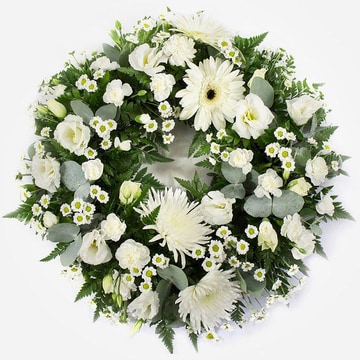 Wreath featuring white chrysanthemum blooms white gerbera white lisianthus white spray carnations on a grey background