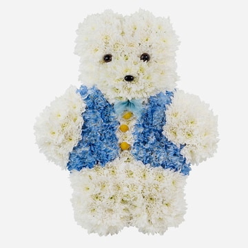 White and blue teddy bear funeral tribute made with chrysanthemum on a grey background