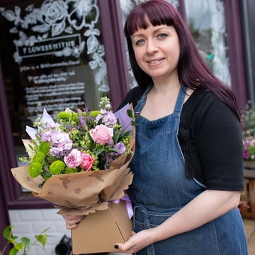 Florist holding a seasonal bouquet for mothers day wrapped in kraft paper florist holding a seasonal bouquet for mothers day wrapped in kraft paper 2