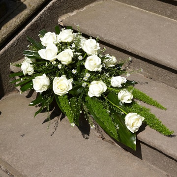 Elegant white rose spray with lush green foliage