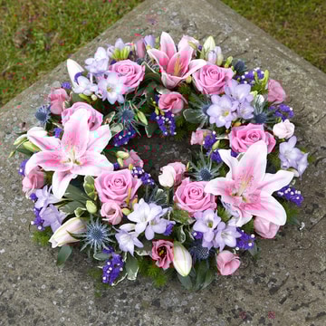 Delicate wreath of pink and lilac flowers with soft greenery