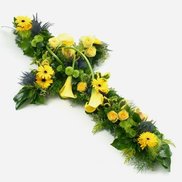 Bright yellow cross arrangement with green foliage