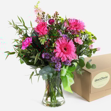 Rosewater charm pink roses gerberas and carnations in a vase with a green ribbon