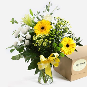 Sunlit shores yellow gerberas white roses and greenery in a vase with a yellow ribbon