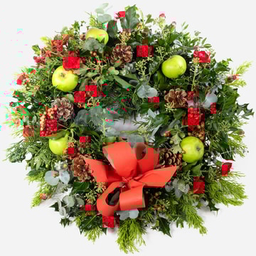 Traditional christmas wreath with festive foliage pinecones apples and a red bow traditional christmas wreath with festive foliage pinecones apples and a red bow