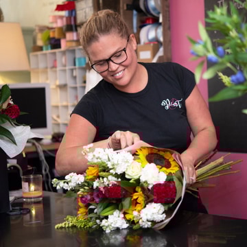 Smiling florist arranging fresh flowers in a shop smiling florist arranging fresh flowers in a shop 2