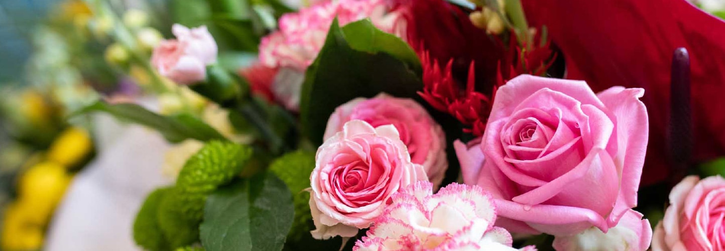 Vibrant bouquet of pink roses, red gerbera, and mixed seasonal flowers