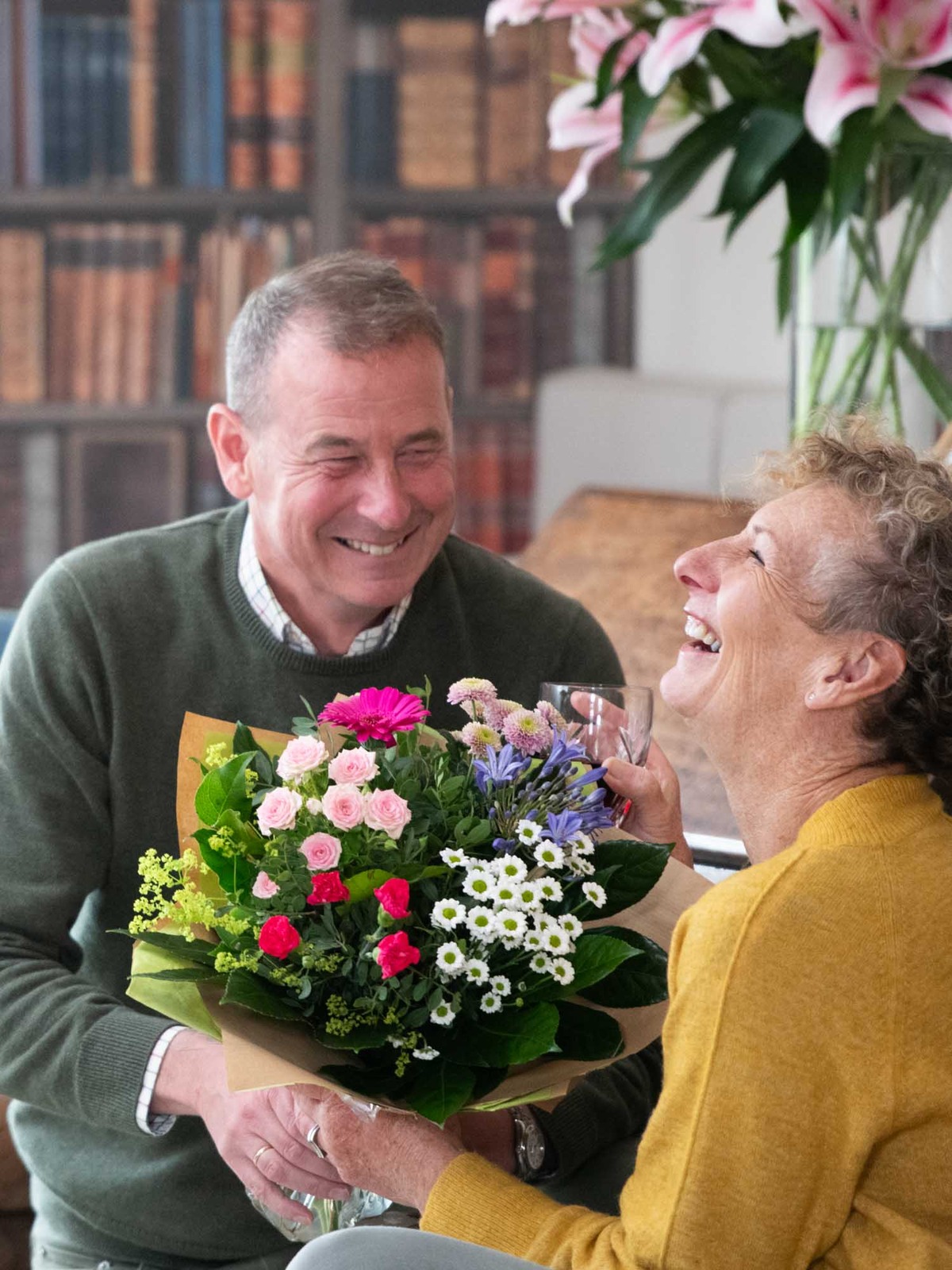 Two friends laughing with fresh flowers from local florist in Ireland in the foreground