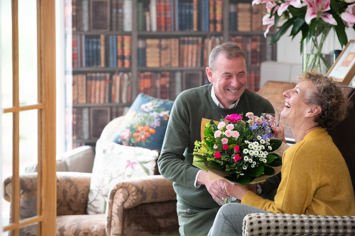Gentleman presenting bouquet to happy new homeowner