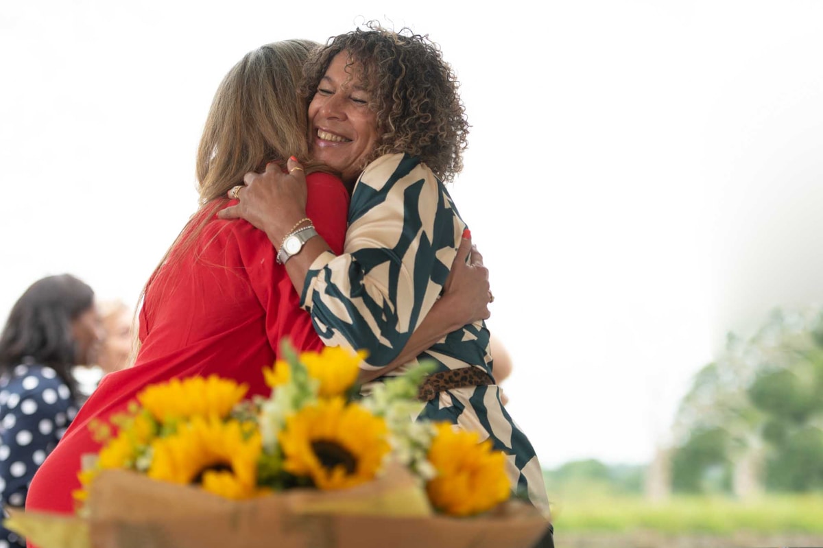 Friends hug after receiving bouquet from local Irish florist