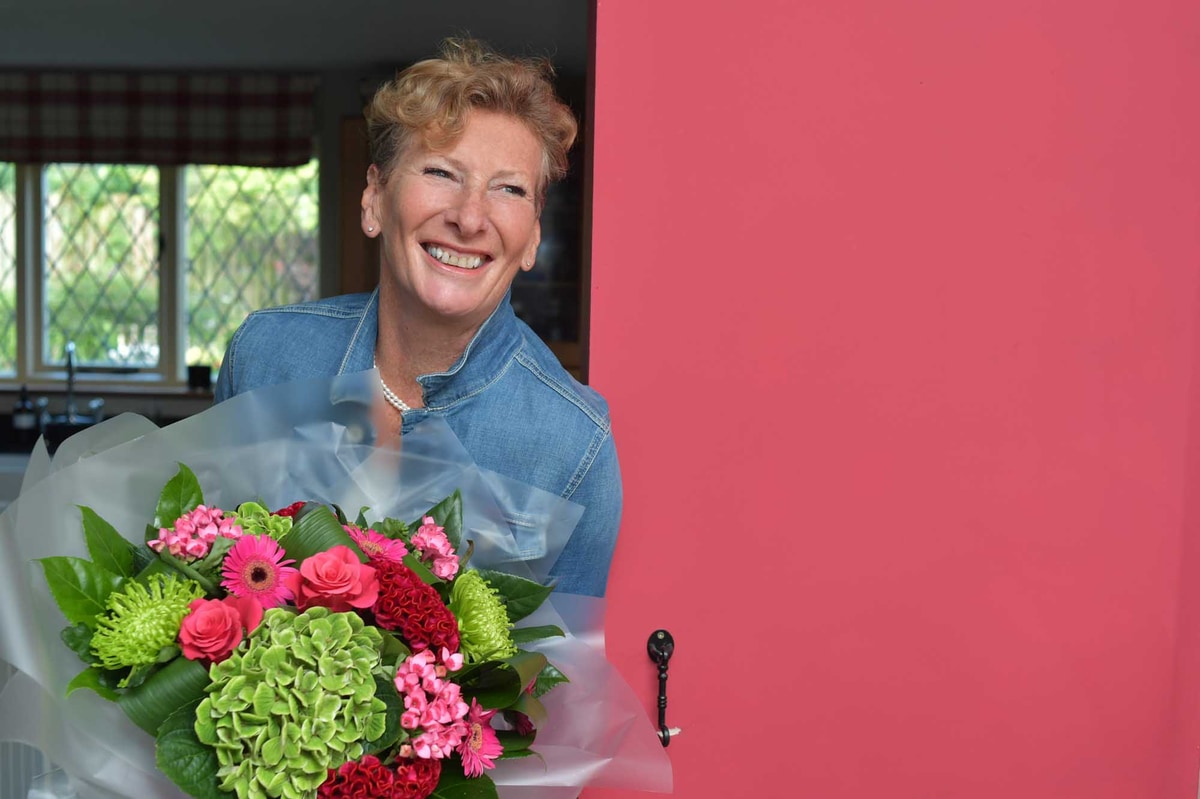 Bouquet of flowers delivered to smiling woman for New Year