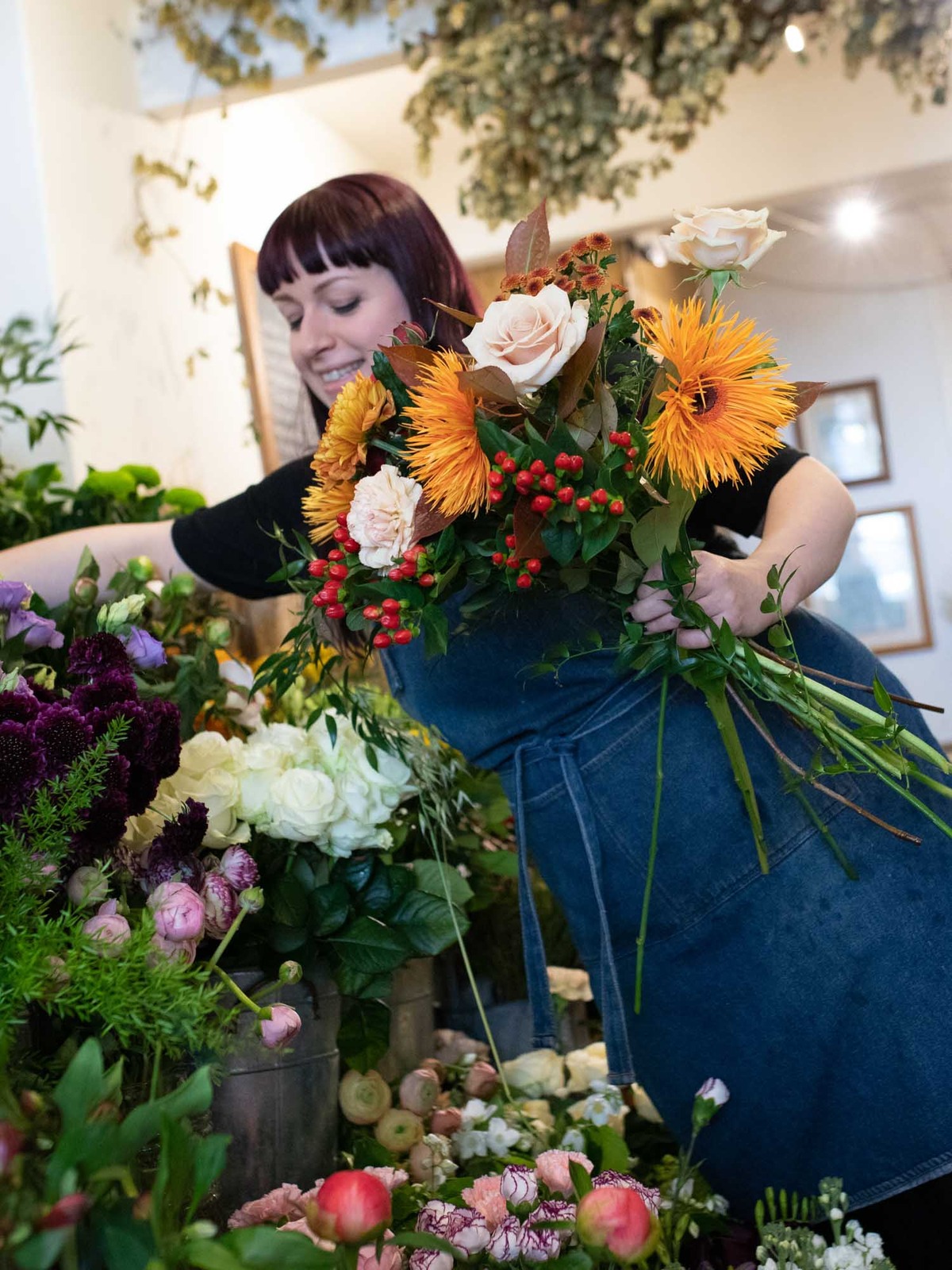 Florist arranging Halloween bouquet from flower stand