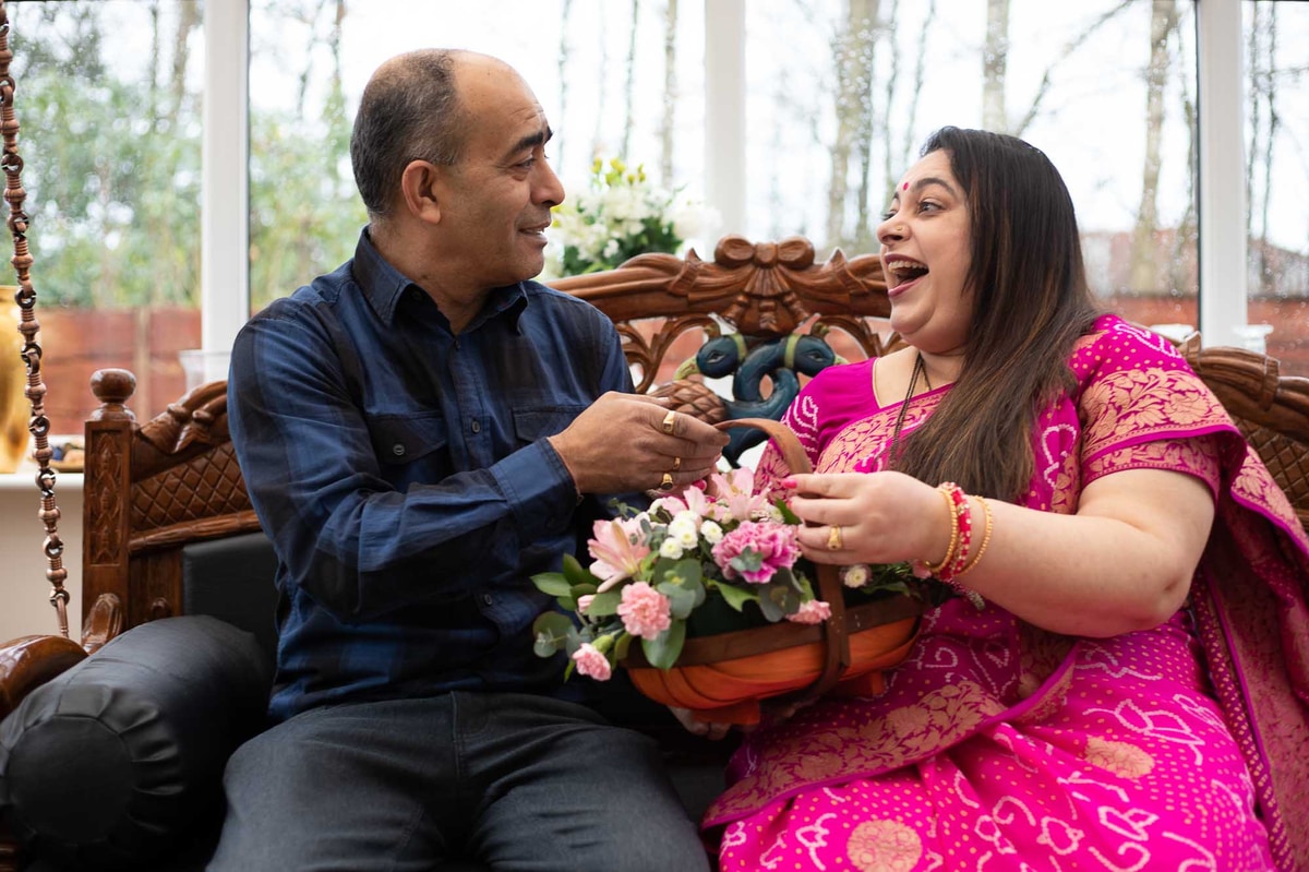 Couple celebrating Diwali with bouquet of flowers