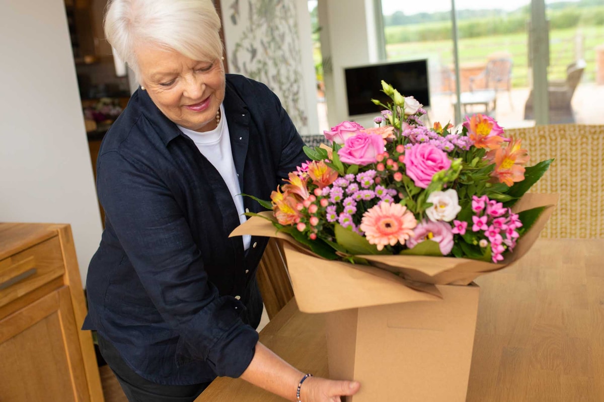 Smiling woman receiving large floral bouquet